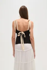 Musculosa negra con breteles finos, escote en V, punto smock y lazos en los hombros.