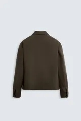Sobrecamisa negra de lana con cuello solapa, manga larga con puños abotonados, bolsillos de vivo en la cadera y cierre frontal con cremallera.