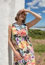 Vestido midi sin mangas con estampado floral multicolor sobre fondo negro y tajos laterales.