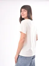 Remera color crudo con estampado de un pez rojo en el frente.