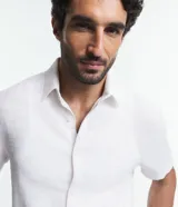 Camisa de manga corta blanca con textura de rayas, cuello inglés y abotonadura frontal.