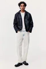 Pantalón de jean de corte holgado, color blanco con efecto desteñido en azul. Diseño de cinco bolsillos y tiro bajo.