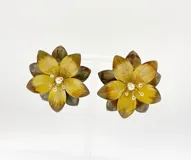 Aros tipo caravanas con forma de flor de metal esmaltado en tonos verde, con centro de perla y strass.