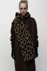 Bufanda rectangular color marrón con estampado de leopardo y flecos cortos en los extremos.