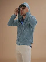 Campera con capucha de toalla de algodón color verde azulado, con cierre frontal y bolsillos laterales.