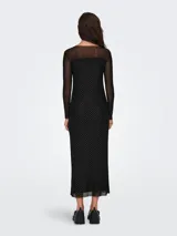 Vestido negro con lunares plateados, corte ajustado, largo a la rodilla, escote redondo y mangas largas de tul transparente.