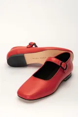 Zapato estilo Mary Jane color marrón, de cuero, con punta redondeada y tira sobre el empeine con hebilla.