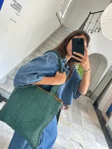 Bolso tote de cuero color marrón con diseño entrelazado.