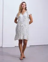 Vestido corto estampado, marca Marissa Olivia. Cuello a la base con frunce y lazo de ajuste. Terminación de ruedo con volado. Forro interno a tono.