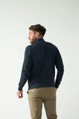 Campera negra de felpa con cierre frontal, bolsillos laterales, puños y logo bordado en el pecho.