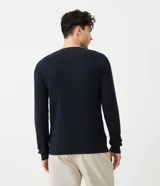 Suéter azul marino de corte slim, cuello redondo y manga larga, confeccionado en algodón texturizado.