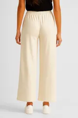 Pantalón beige holgado de algodón con cintura elástica.