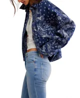 Chaqueta tipo camisa de tejido grueso, color azul marino con estampado tipo bandana en blanco y gris. Presenta cuello camisero, botones frontales y bolsillos de parche en el pecho.