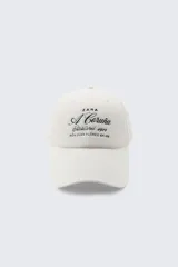 Gorra de béisbol color crudo de Zara con bordado frontal con la leyenda "A Coruña Established 1975 Rúa Juan Flórez 64-66".