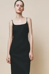 Vestido midi negro de breteles finos regulables, escote recto y abertura en el ruedo.
