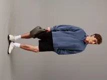 Riñonera de poliuretano color gris topo, con textura granulada y logo 'CK' grabado en el frente. Posee una correa ajustable de tela marrón oscuro.