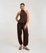 Pantalón de mujer color marrón oscuro, estilo balloon o bombacho, con cintura y puños elásticos.