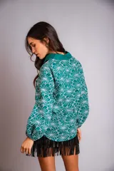 Camisa celeste con estampado de flores blancas, corte clásico, cuello camisero y mangas largas abullonadas.