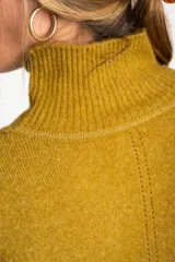 Polera color crema de tejido de punto, con cuello alto y mangas largas.