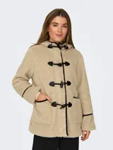 Abrigo de tela tipo teddy color beige, con capucha, cierre con botones tipo duffle coat y bolsillos frontales. Detalles en cuero sintético negro en los bordes y en los botones.