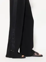 Pantalón negro de satén doble, de pata ancha y cintura elastizada.