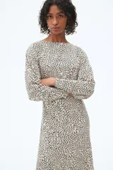 Vestido midi de manga larga con estampado animal en tonos beige y negro.