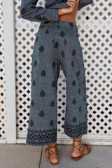 Pantalón culotte de tiro alto con trabillas, bolsillos laterales y traseros. Detalle de bordados combinados a contraste. Cierre frontal con cremallera y botón.