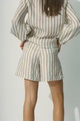 Short a rayas verticales color beige y blanco, de corte holgado y cintura elástica.