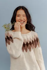 Sweater tejido a mano en Uruguay con lana merino color crudo, con diseño geométrico en tonos marrón y beige en la parte superior.