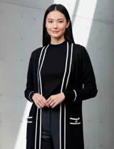 Cardigan largo de punto marca Via Milano, color negro con detalles de rayas blancas en contraste. Presenta un diseño abierto sin botones, bolsillos frontales aplicados y ribetes blancos en la apertura, puños y bolsillos.