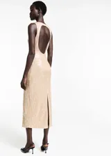 Vestido de fiesta largo color dorado con lentejuelas, cuello halter y espalda descubierta.