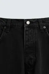 Pantalón de jean negro de corte amplio, estilo balloon fit, con cinco bolsillos y cierre frontal con botones.