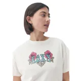 Remera color crudo de corte recto, con estampado de flores y el logo de la marca en el frente.