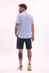 Bermuda de lino color beige, corte recto, con bolsillos laterales y traseros.