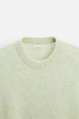 Sweater verde claro de lana y alpaca, con cuello redondo y mangas largas.