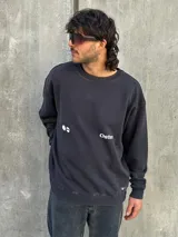 Buzo negro de corte holgado con estampa en la espalda que incluye una estrella blanca, la palabra "Osen" y las palabras "Empower", "Elevate", "Boldness" y "Strength".