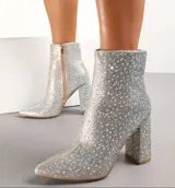 Bota corta plateada cubierta de strass, con punta fina, cierre lateral y tacón cuadrado. 