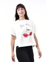 Remera blanca de corte holgado con estampado de labios rojos y cerezas, y la frase 'Ma cherie' en cursiva negra.
