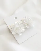 Aros tipo caravana con forma de flor, color blanco perlado.