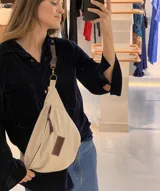 Riñonera de cuero color marrón, con correa regulable y bolsillo interno con cierre.