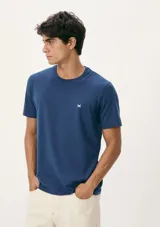 Camiseta azul de corte clásico, cuello redondo y manga corta, con logo bordado en el pecho.
