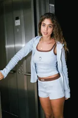 Musculosa de punto acanalado color celeste, con ribete marrón en el cuello y las sisas, y un pequeño bordado de fresa en el pecho.