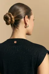 Top sin mangas negro, con cuello alto y hombros ligeramente estructurados. El tejido presenta una textura sutil con brillo integrado que simula un animal print.