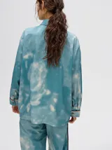 Camisa oversize celeste con estampado tie-dye, bolsillo en el pecho con bordado y terminaciones con ribete en contraste.