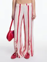 Pantalón de lino y viscosa a rayas verticales rojas y beige, de corte ancho con aberturas laterales en el ruedo y lazos para ajustar.