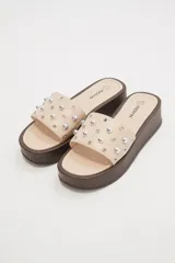 Sandalias color beige con plataforma marrón y apliques de tachas plateadas.