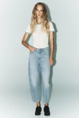 Pantalón de jean celeste de corte amplio, con tiro medio, cinco bolsillos y costuras torcidas.
