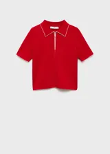 Jersey rojo de punto fino con cuello polo y cierre de cremallera parcial. Tiene manga corta y ribetes blancos en cuello y mangas.