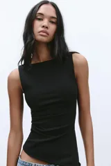 Musculosa negra con cuello barco, sin mangas, detalle de pliegues laterales y bajo asimétrico.