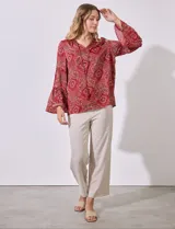 Blusa de satén estampada en tonos azules, con escote en V y lazo, y mangas largas con volados.